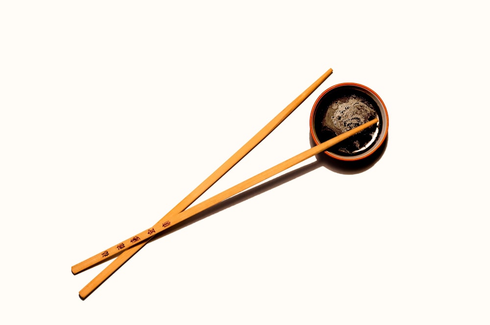 brown wooden chopsticks with black round container