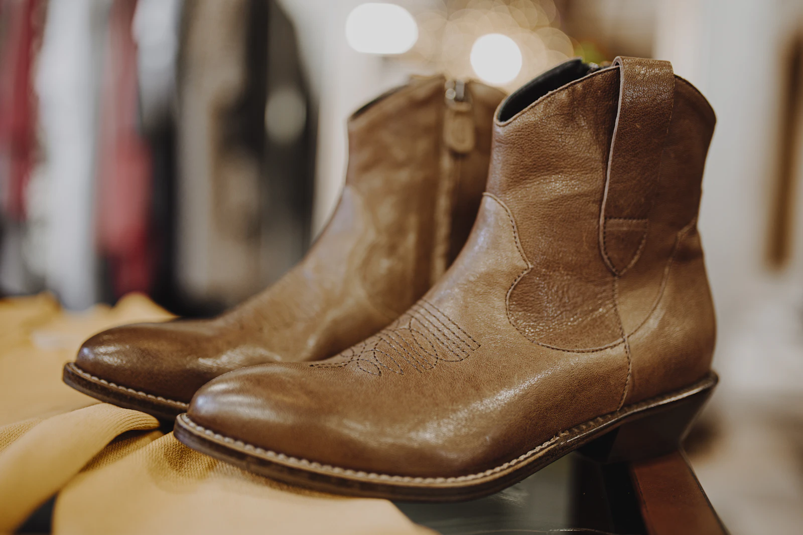 Brown leather boots on a wooden shelf