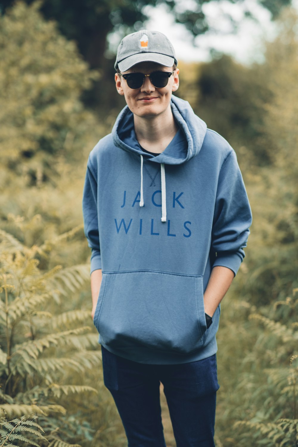 man in gray hoodie standing on green grass field during daytime