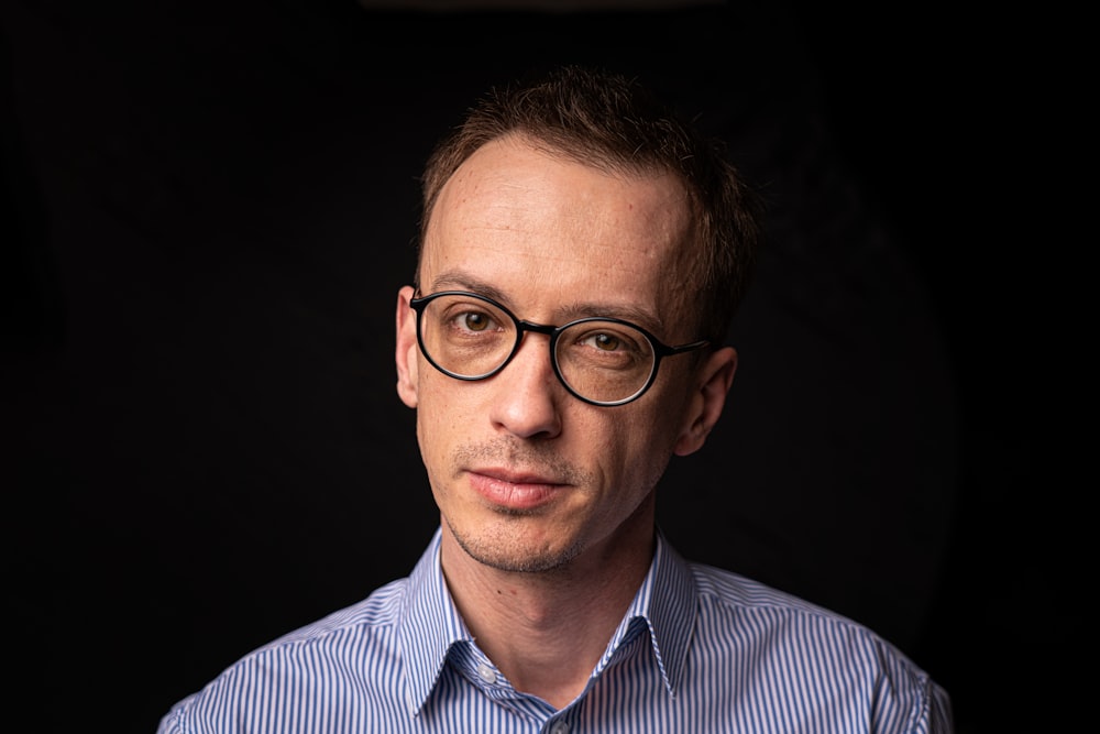 man in blue and white striped dress shirt wearing black framed eyeglasses