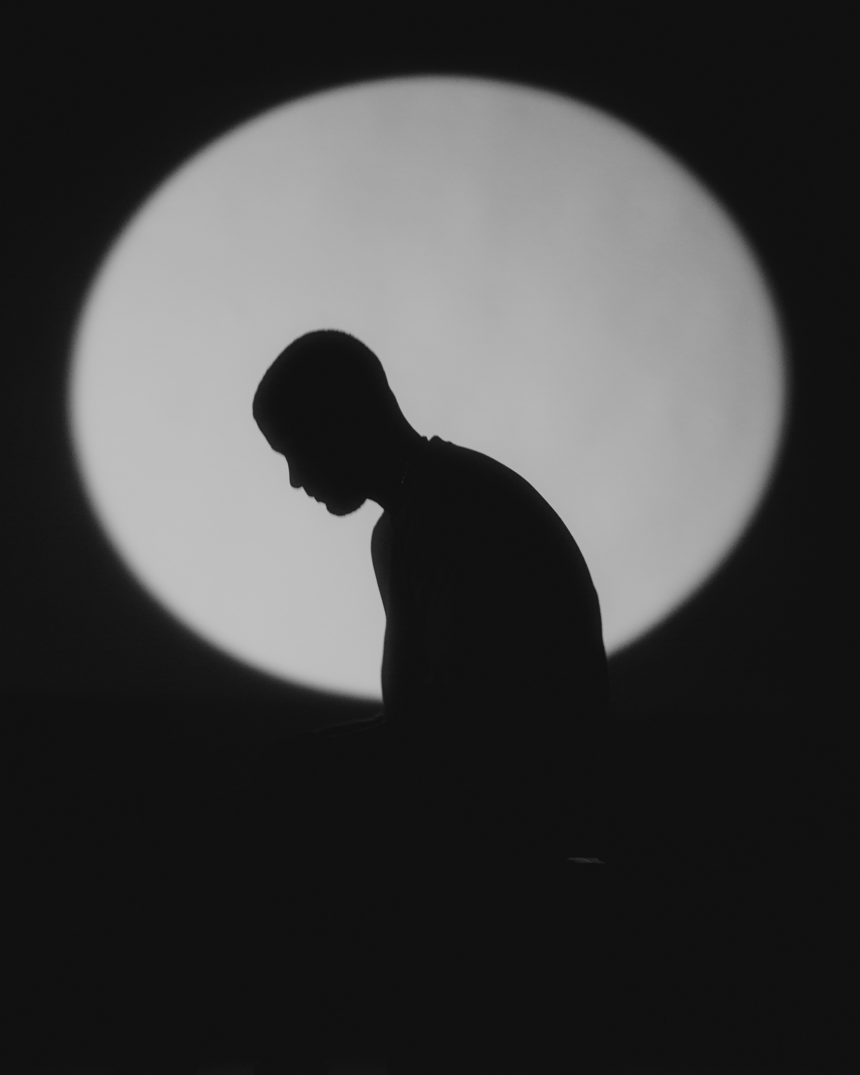 silhouette of man sitting on floor