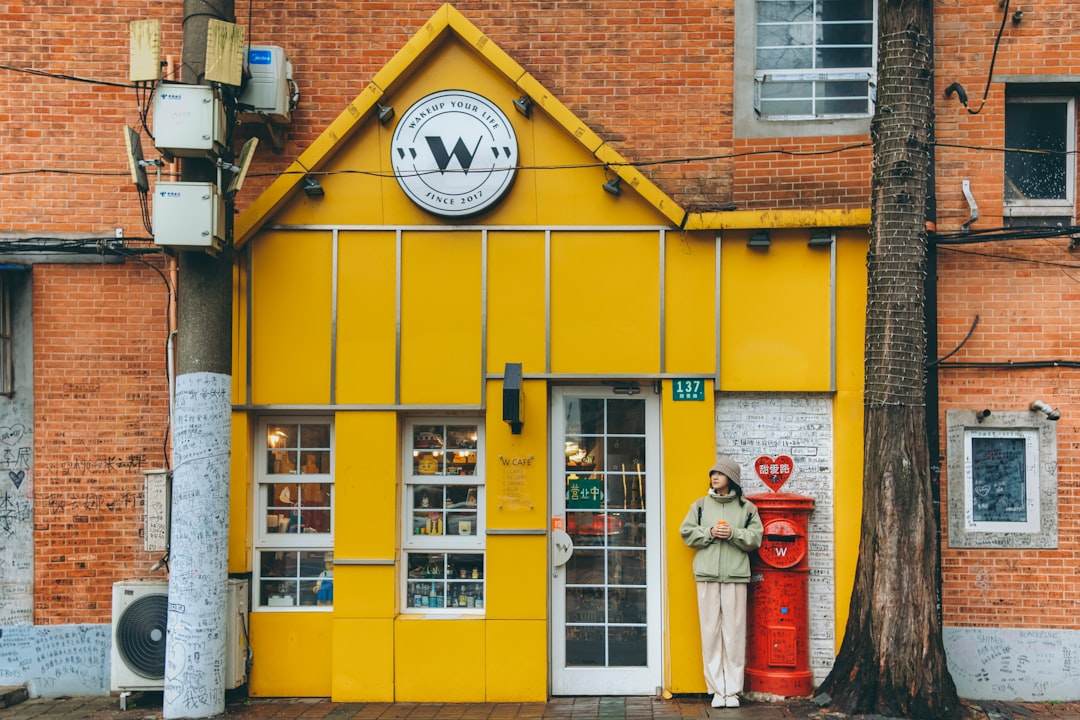 yellow and red concrete building with analog wall clock