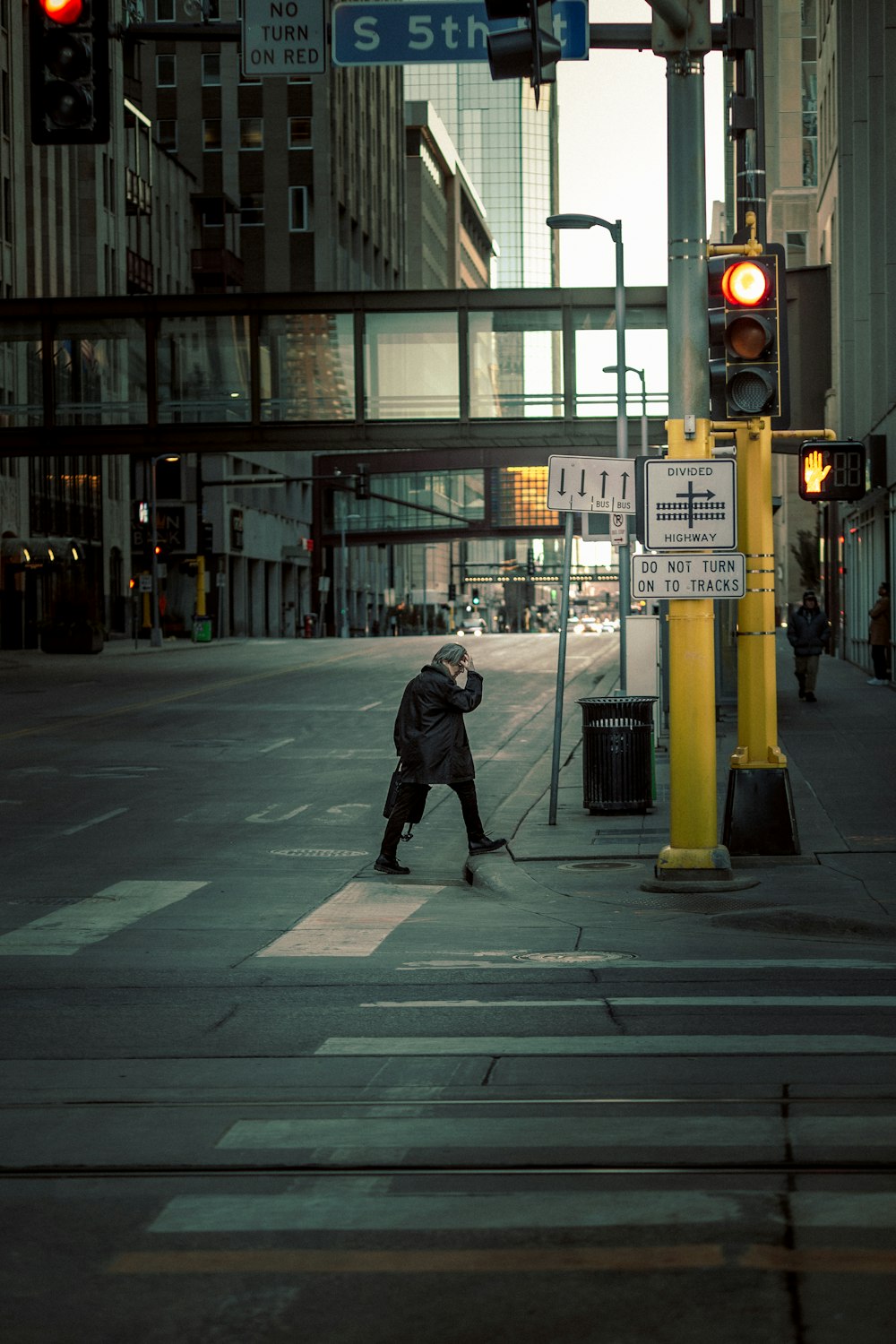 man in black jacket walking on sidewalk during night time