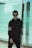 man in black jacket standing near glass wall
