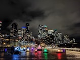 A vibrant cityscape at night illuminated by colorful LED technology installations.