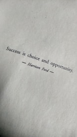 Text on a textured paper background reads 'Success is choice and opportunity' attributed to Harrison Ford.