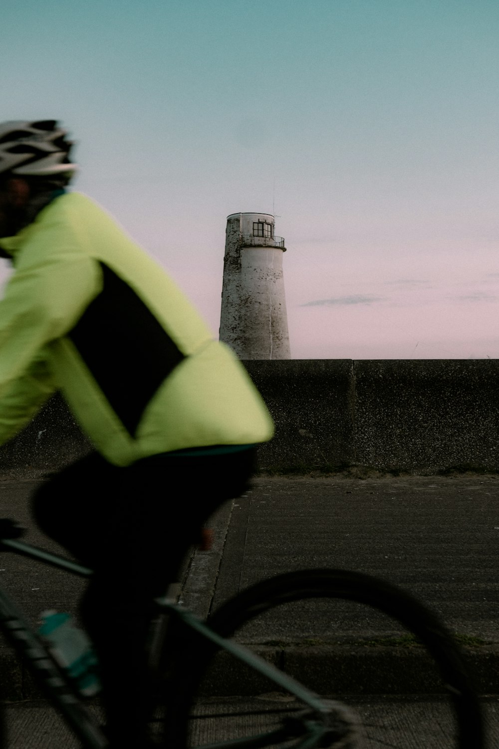 man in green hoodie and black pants riding bicycle on road during daytime