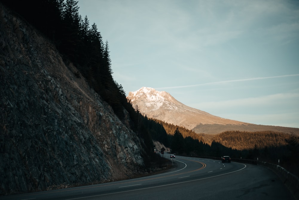 black car on road near brown mountain during daytime