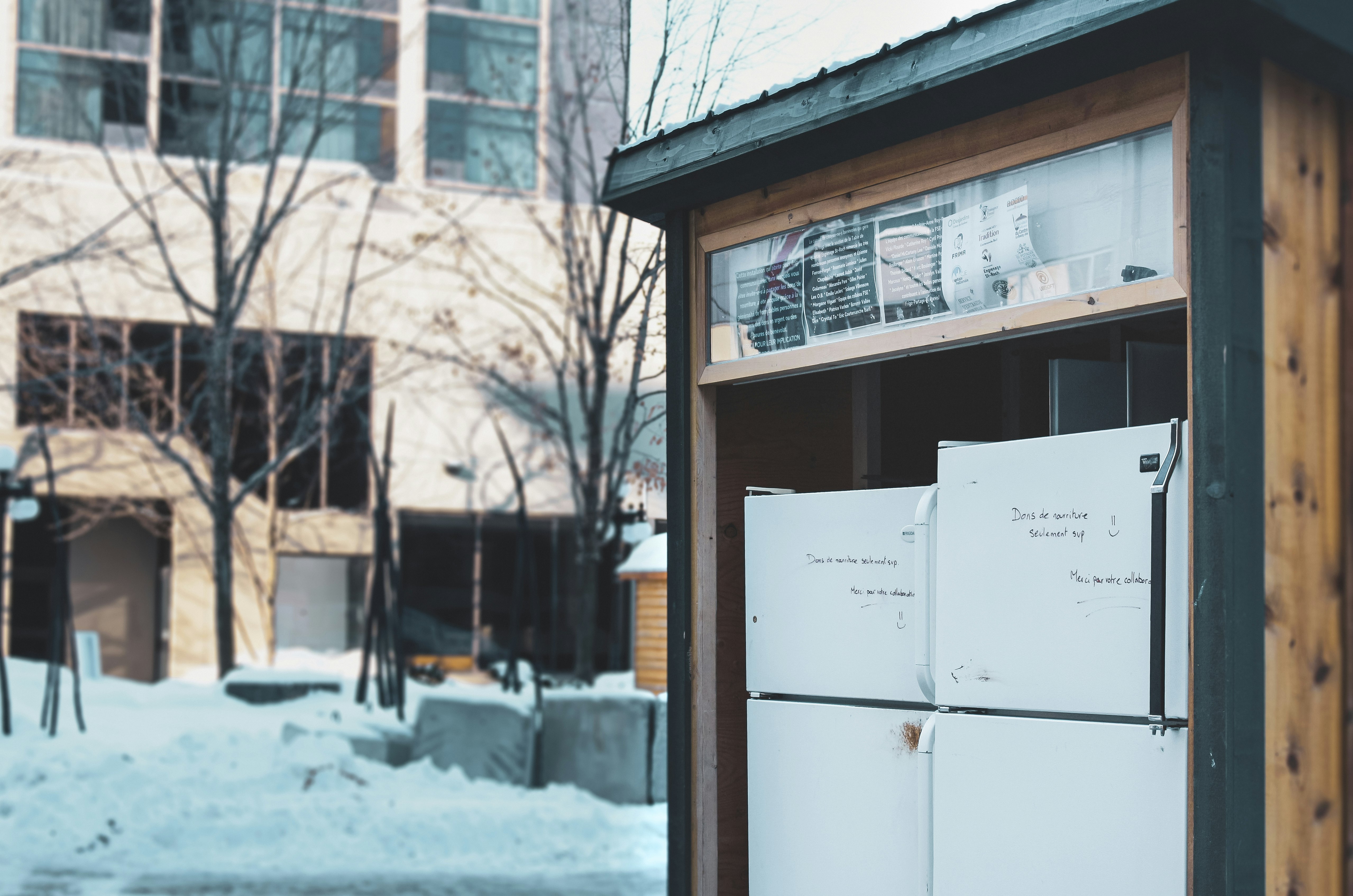 white top mount refrigerator near brown wooden framed glass window