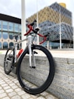 Close-up of a colorful road bike leaning against a city wall