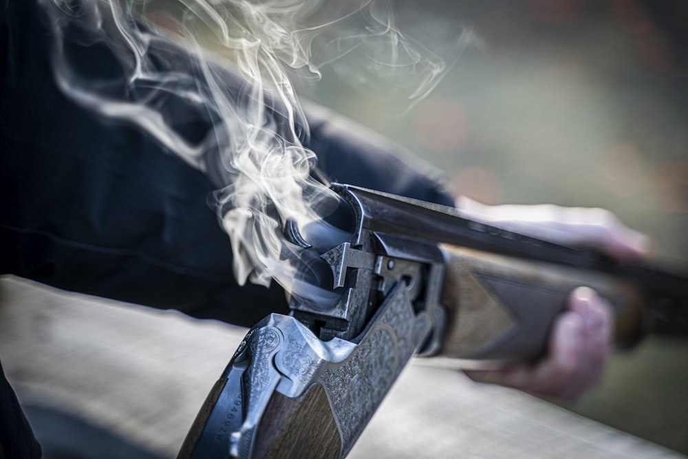 black semi automatic pistol with white smoke