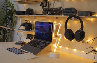 black and silver laptop computer beside black and gray headphones