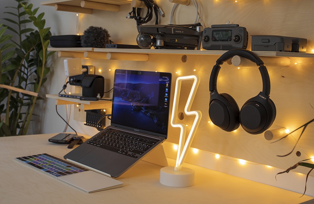 black and silver laptop computer beside black and gray headphones