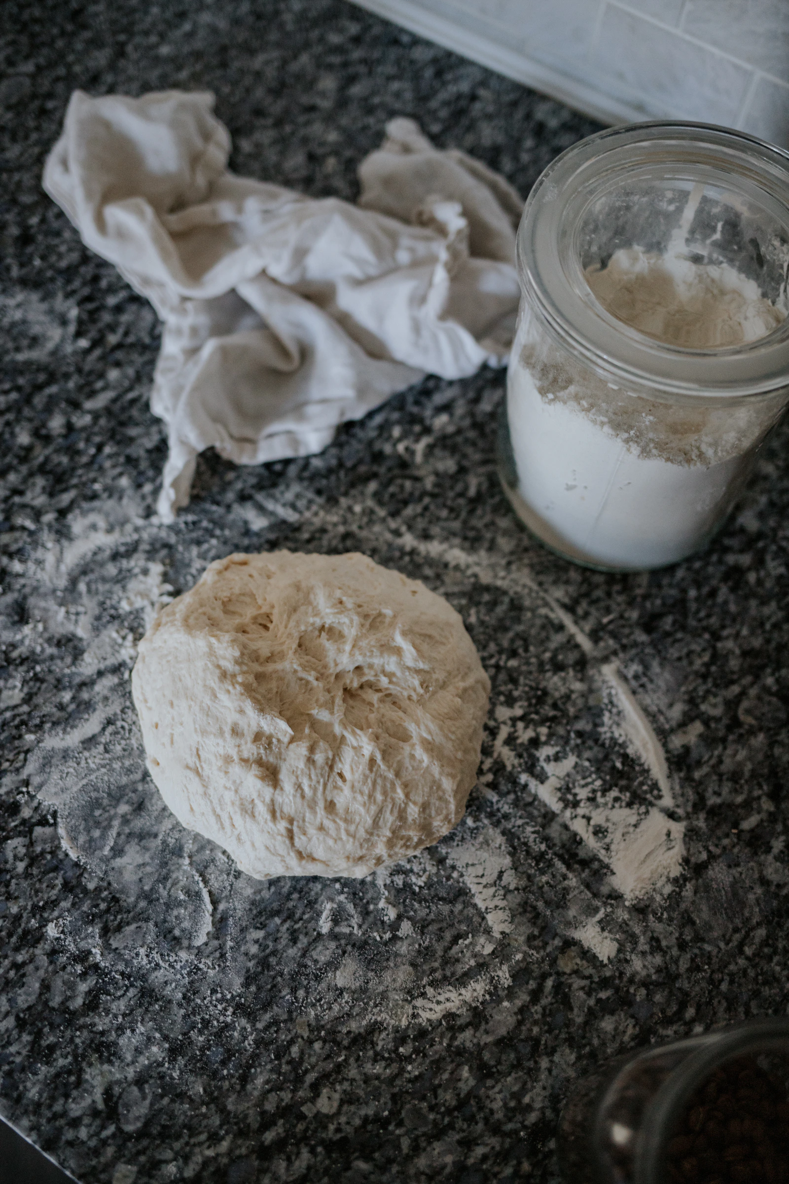 A jar of sourdough starter on a kitchen counter