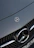 Close-up of a sleek Mercedes-Benz grille gleaming under soft showroom lighting.