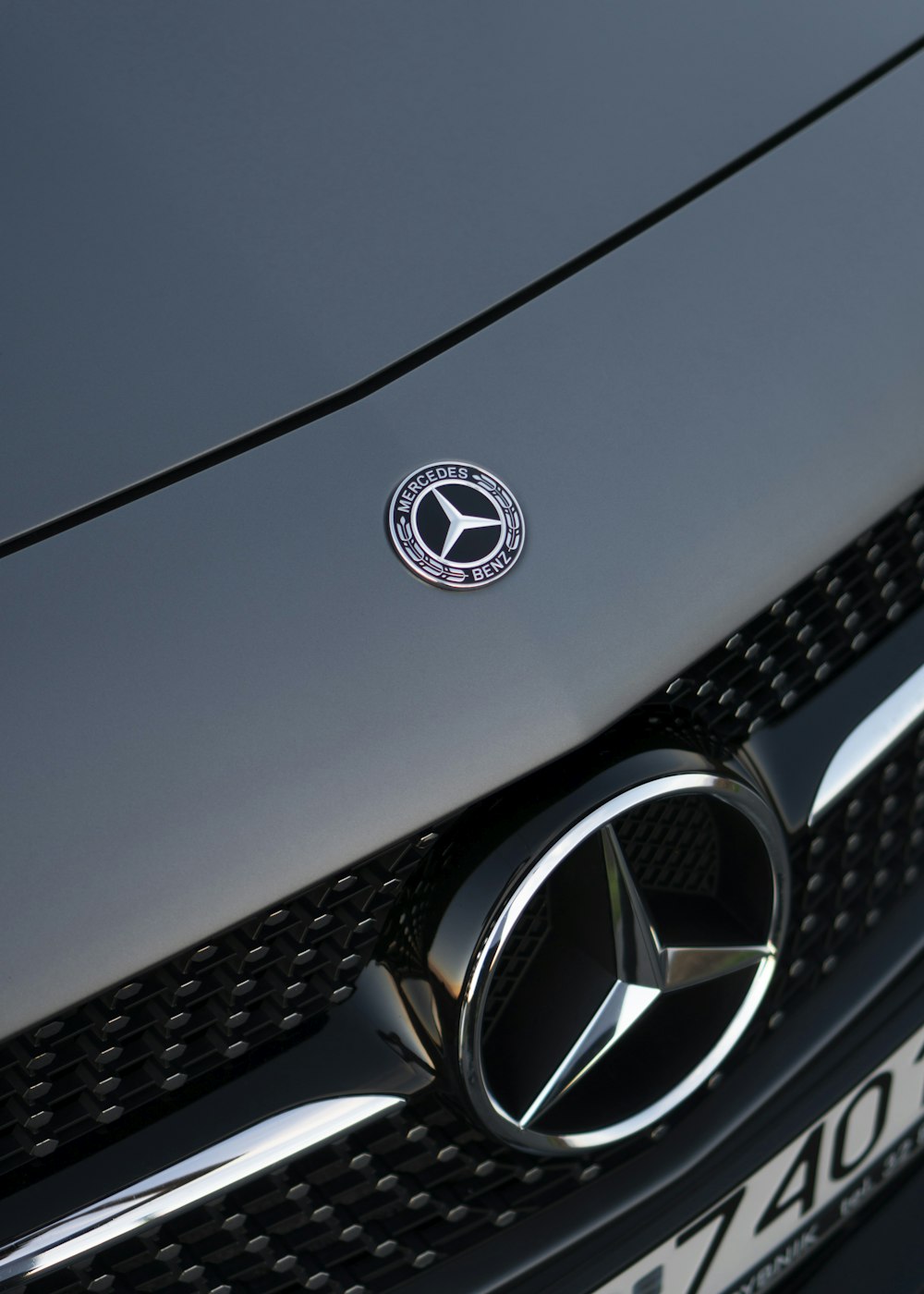 silver mercedes benz emblem on gray car