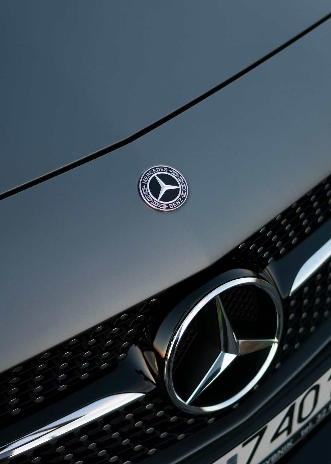 silver mercedes benz emblem on gray car