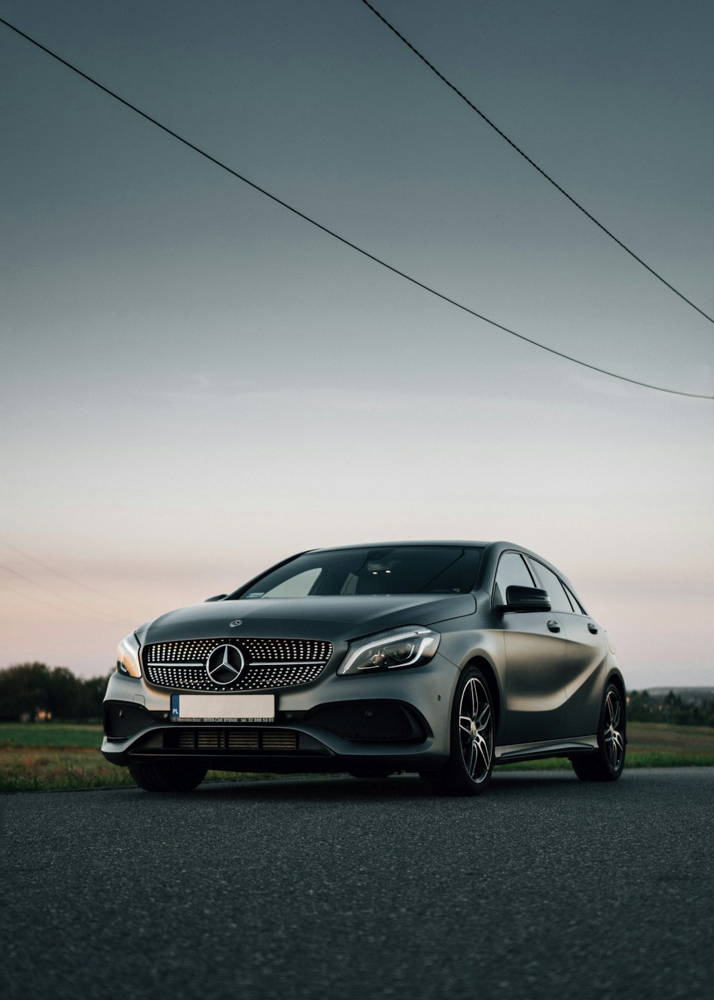 silver mercedes benz coupe on green grass field during daytime