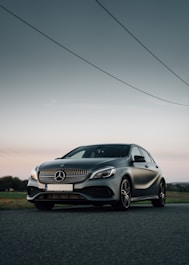 silver mercedes benz coupe on green grass field during daytime