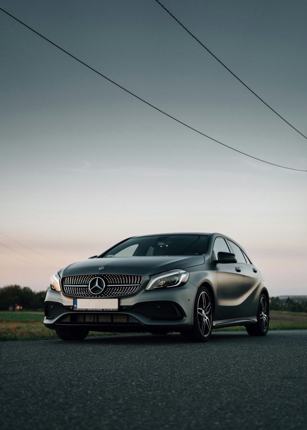 Silbernes Mercedes Benz Coupé tagsüber auf grünem Rasen