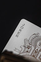Close-up of the Fool tarot card with intricate gold accents on a deep indigo background.