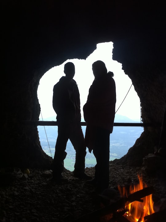 silhouette of man and woman standing in cave during daytime in Salzburg Austria