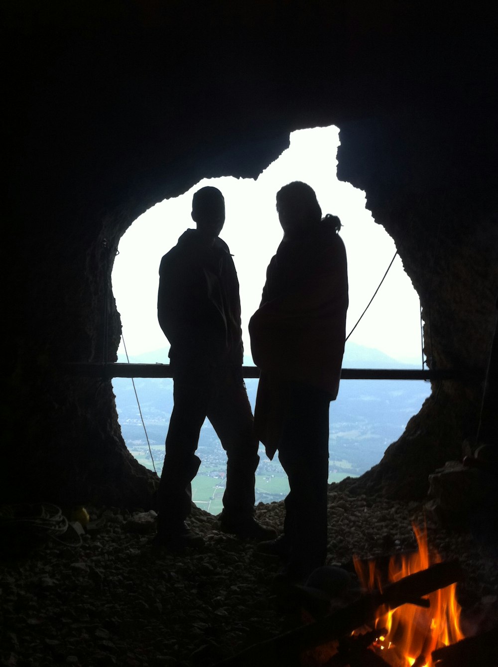 silhouette of man and woman standing in cave during daytime