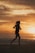 silhouette of woman standing on beach during sunset