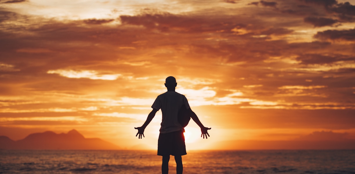 silhouette of man running on beach during sunset