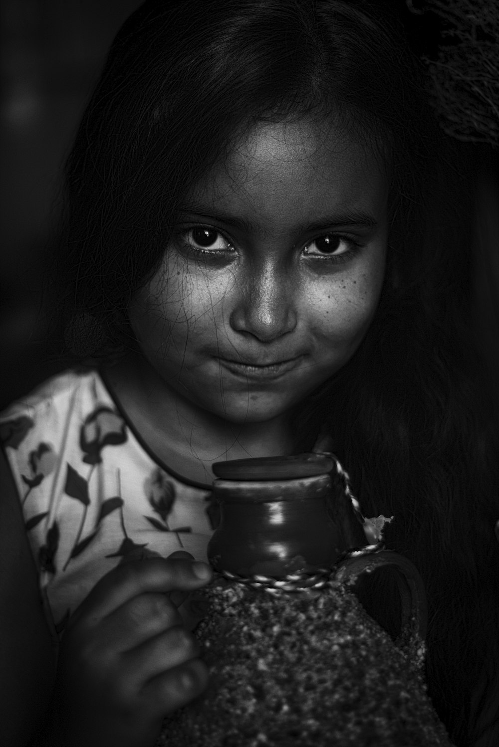 woman in black and white shirt holding clear glass jar