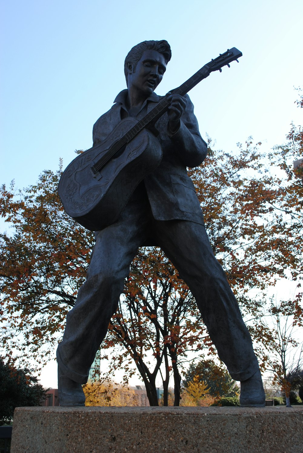 man holding stick statue under white sky during daytime