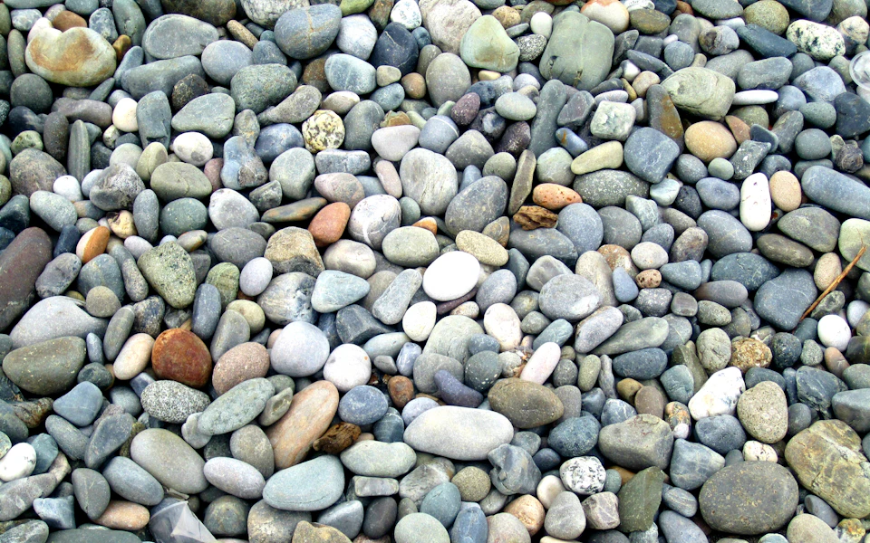 Close-up view of rocky beach with scattered small rocks in various sizes and colors