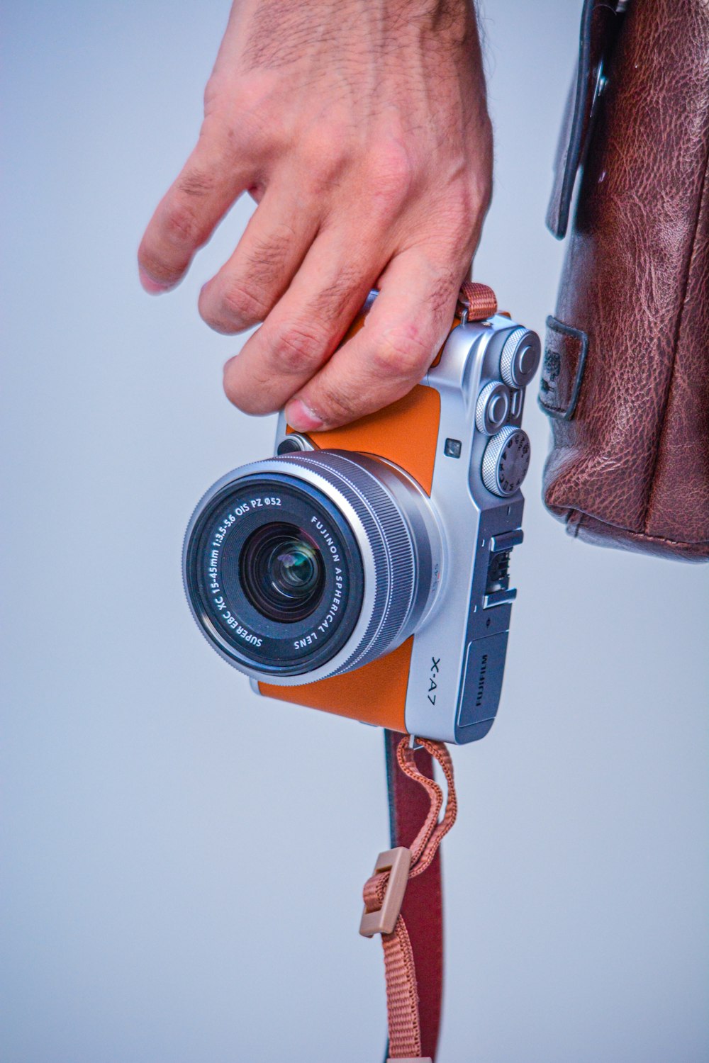 person holding silver and black camera