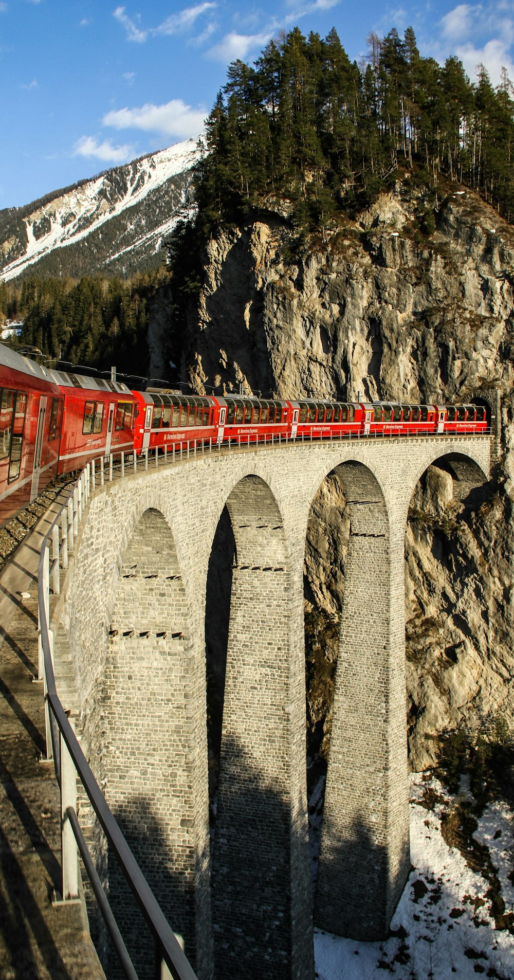 Roter Zug auf brauner Brücke