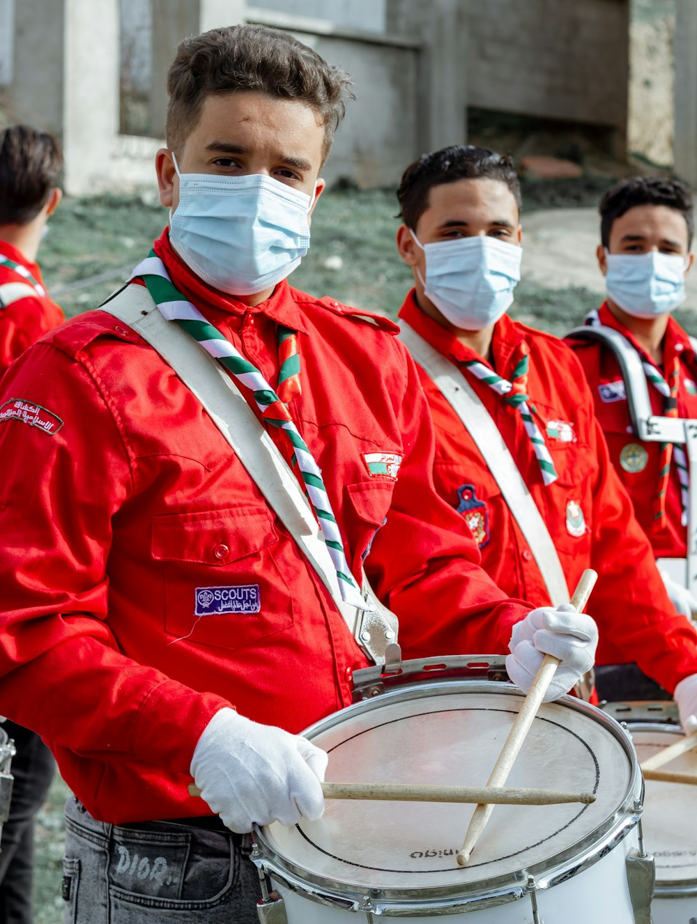 2 men in red and white uniform playing drum