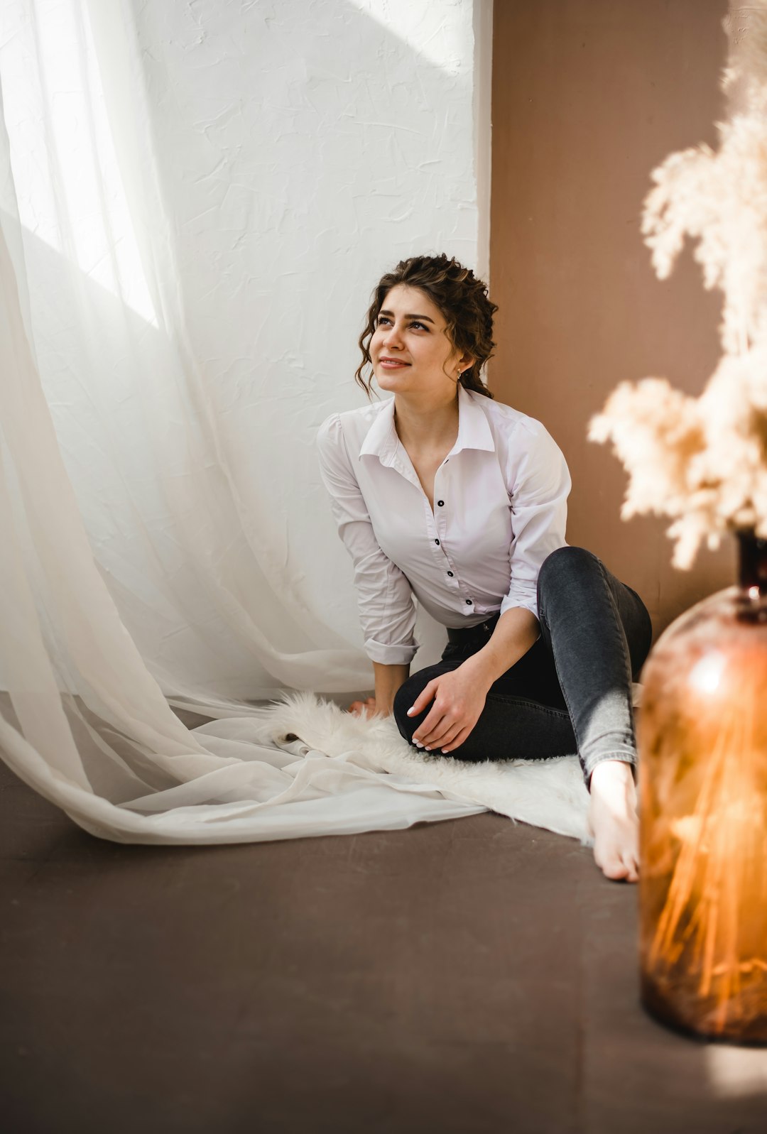 woman in white blazer and black pants sitting on floor