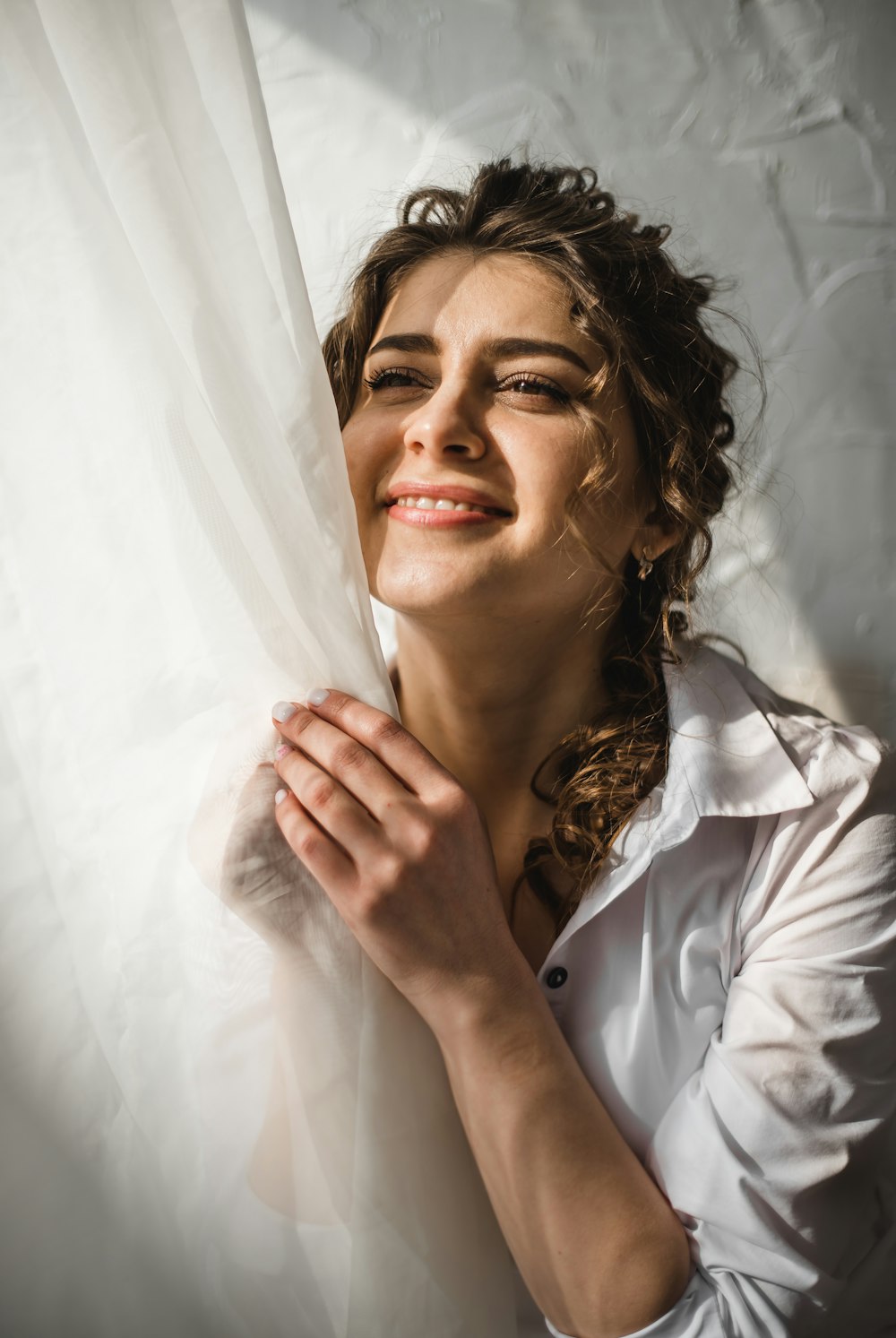 woman in white button up shirt holding white textile