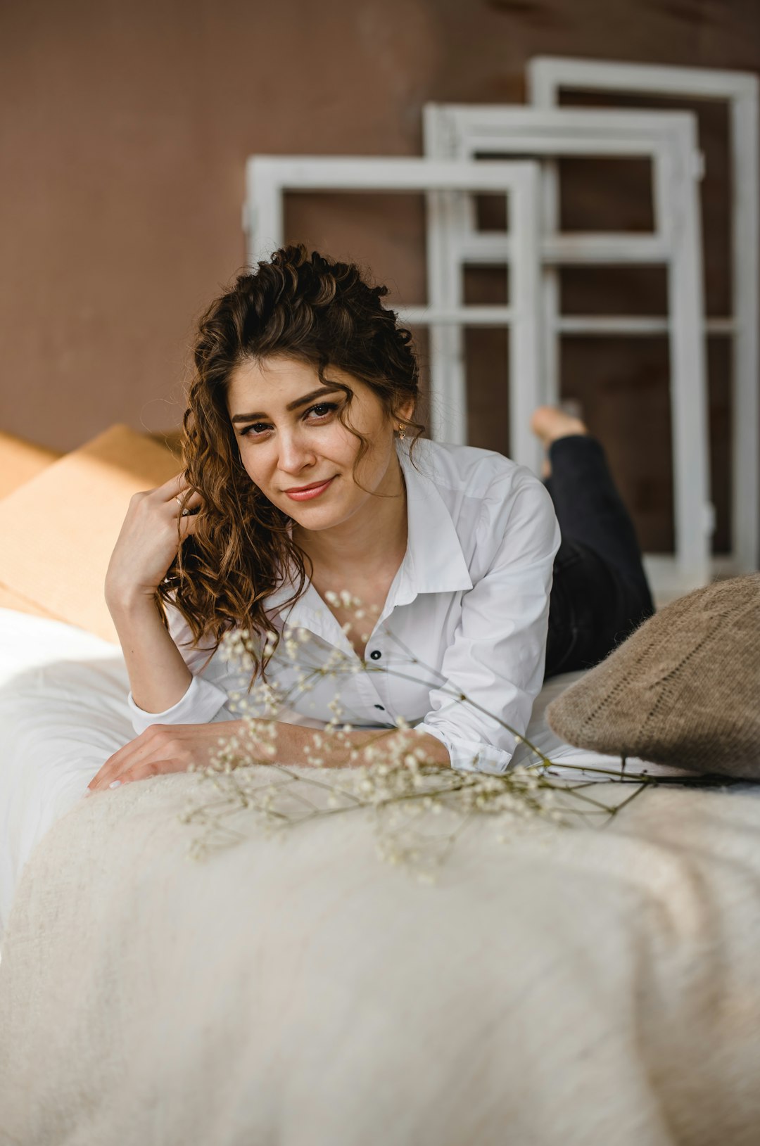 woman in white blazer sitting on bed