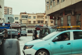 man in black jacket and black pants standing beside white car during daytime
