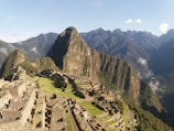 A scenic view of ancient Mexican ruins surrounded by lush greenery under a clear sky.