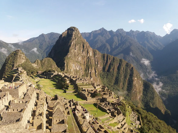 A serene view of Machu Picchu at sunrise, highlighting ancient stone terraces and misty mountains.