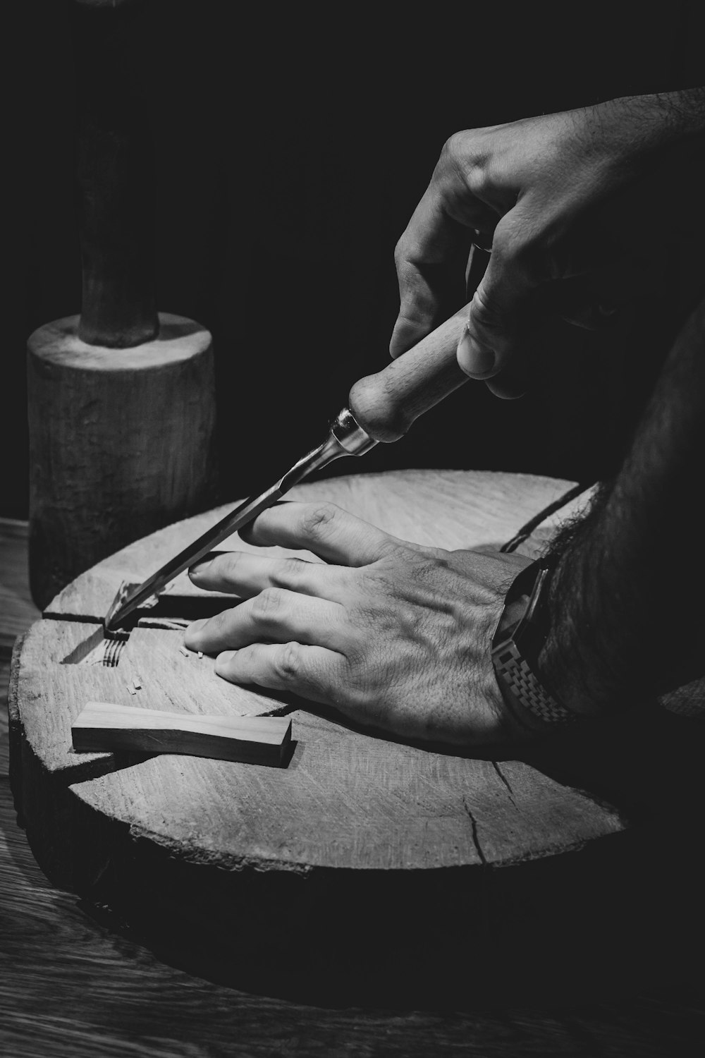 person holding a pen and a round metal container