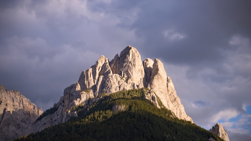 montagne rocheuse sous ciel nuageux pendant la journée