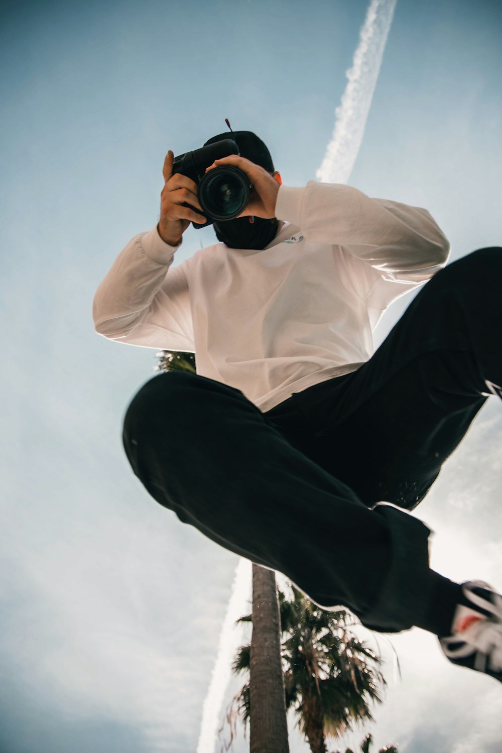 man in white dress shirt and black pants holding black dslr camera