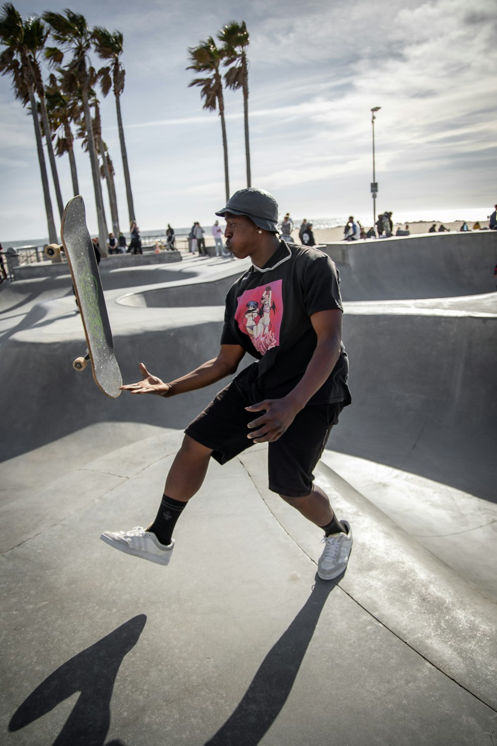 man in blue crew neck t-shirt and black shorts sitting on skateboard during daytime