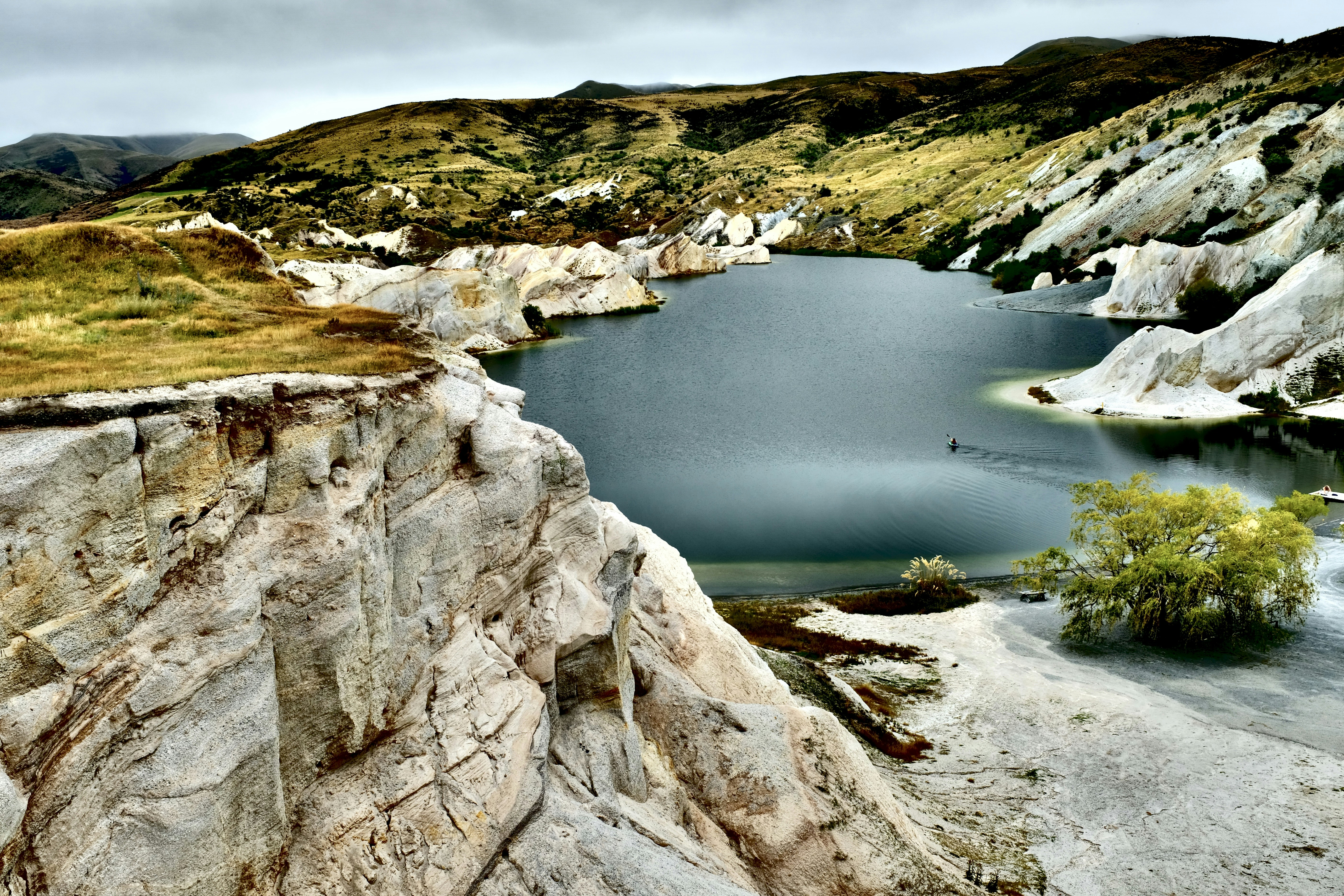 body of water between gray rocky mountain during daytime