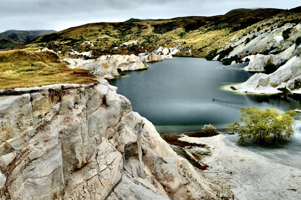 body of water between gray rocky mountain during daytime