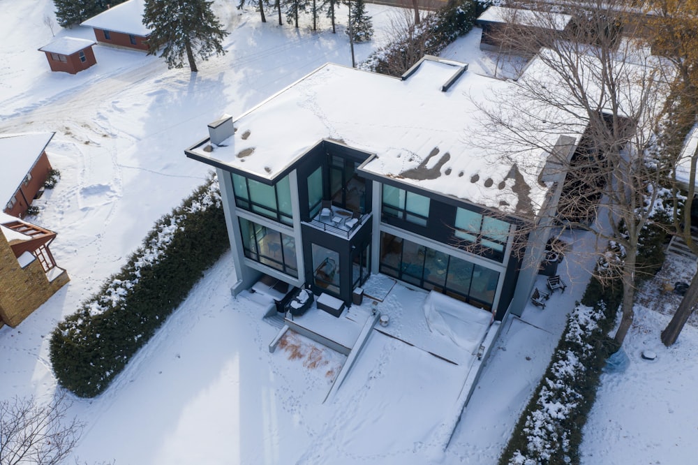 Casa de madera azul y blanca en suelo cubierto de nieve