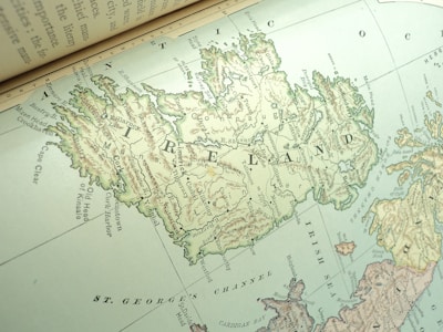 A detailed vintage map of Ireland is depicted, showing various towns, geographical features, and bodies of water. The map includes labelled regions and is oriented at an angle, giving a dynamic presentation of the island's topography.