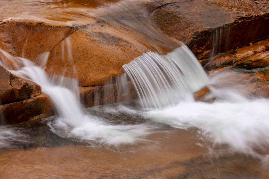 water falls on brown rocky mountain